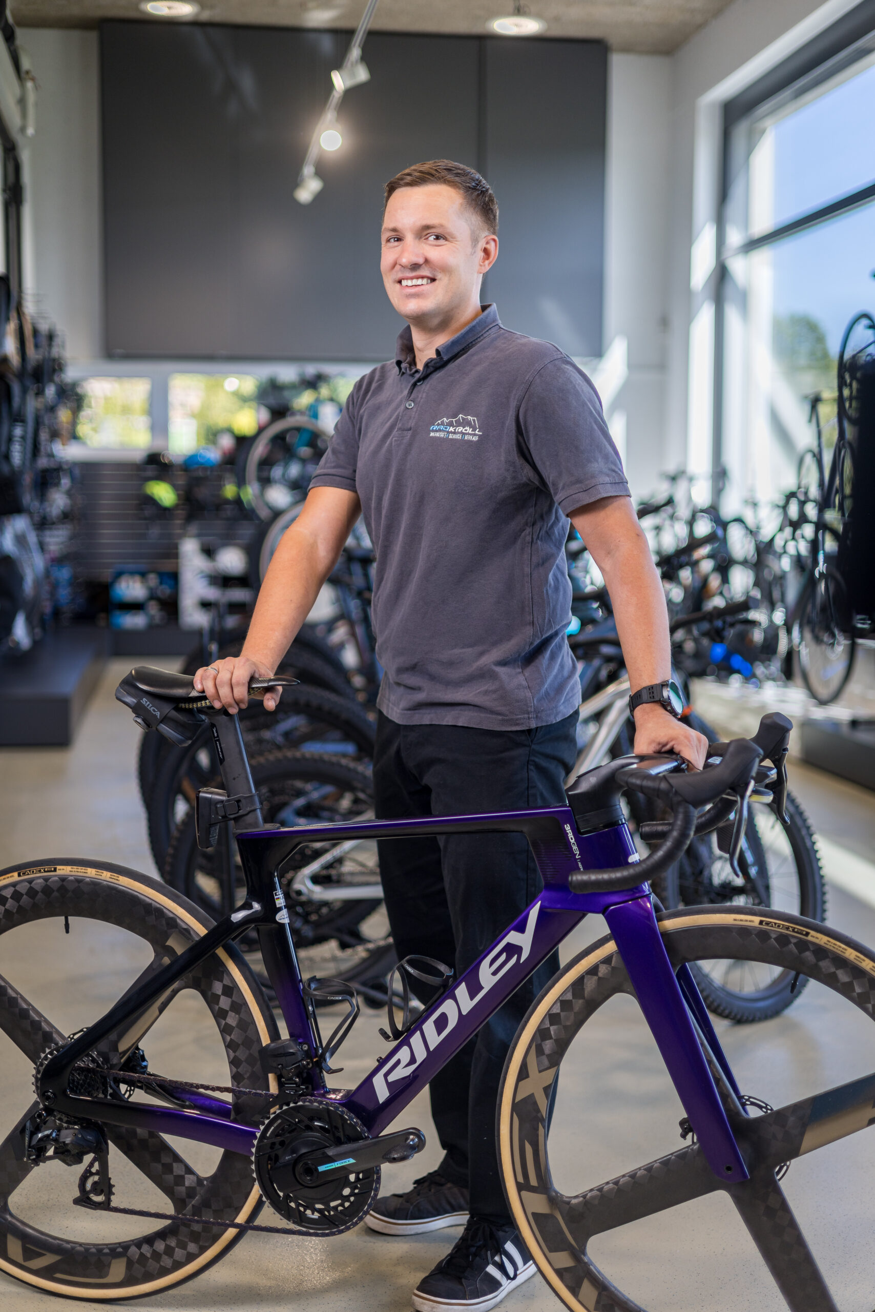 Alois Kröll, Inhaber von Rad Kröll, steht im Verkaufsraum neben einem Ridley Rennrad mit Carbonlaufrädern