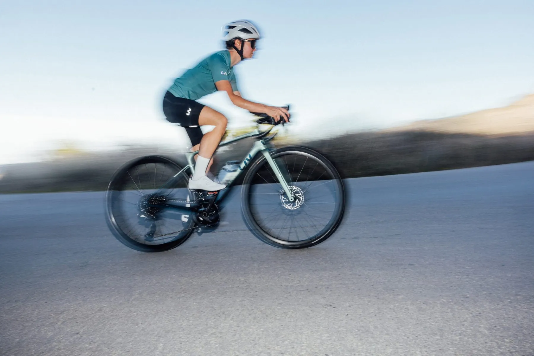 Radfahrerin auf einem Liv Rennrad mit hohen Carbonfelgen in aerodynamischer Sitzposition